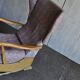 Vintage brown wooden rocking chair from the 1950s, wingback backrest and rocking base.