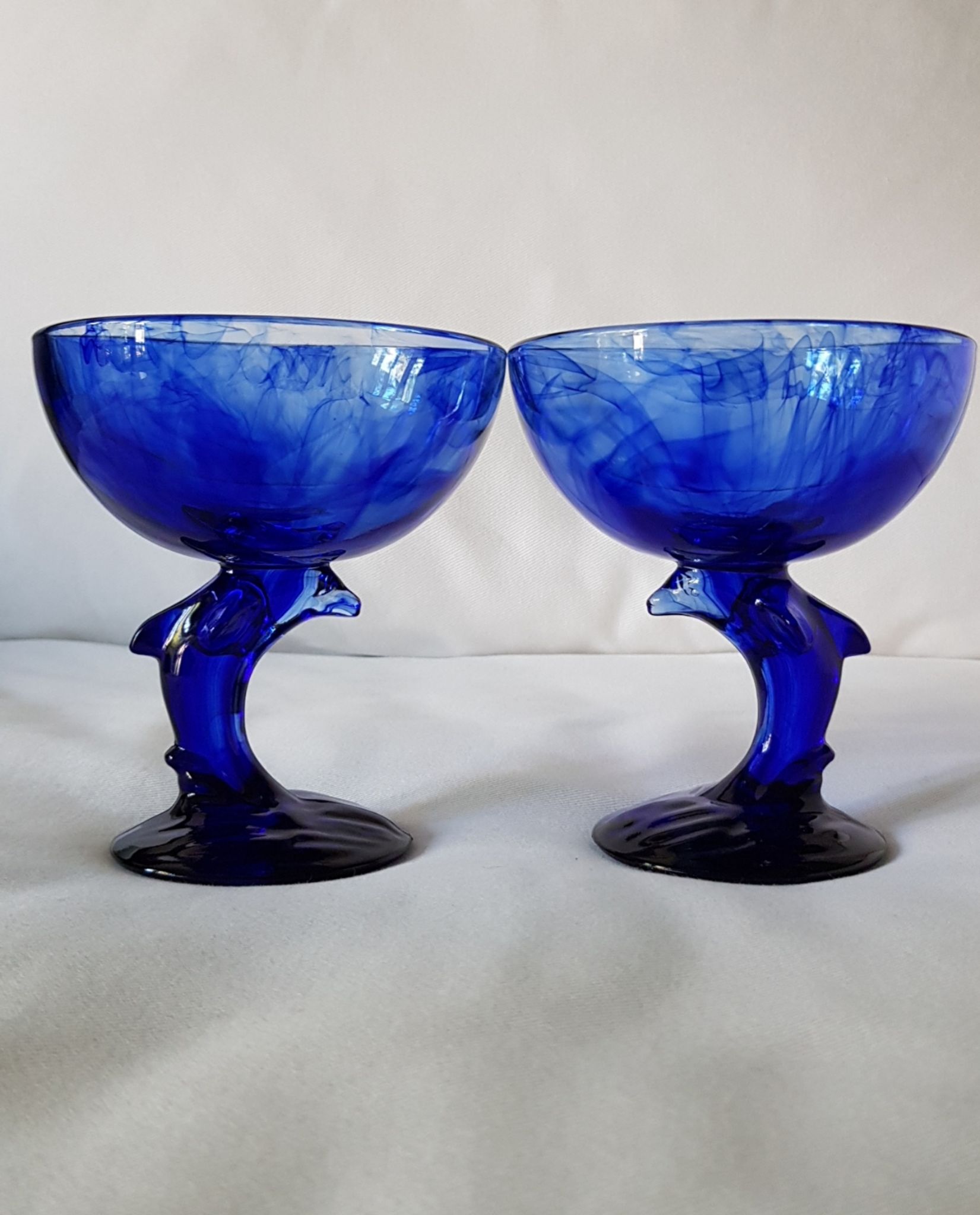 Set of 2 dolphin dessert cups in blue glass.