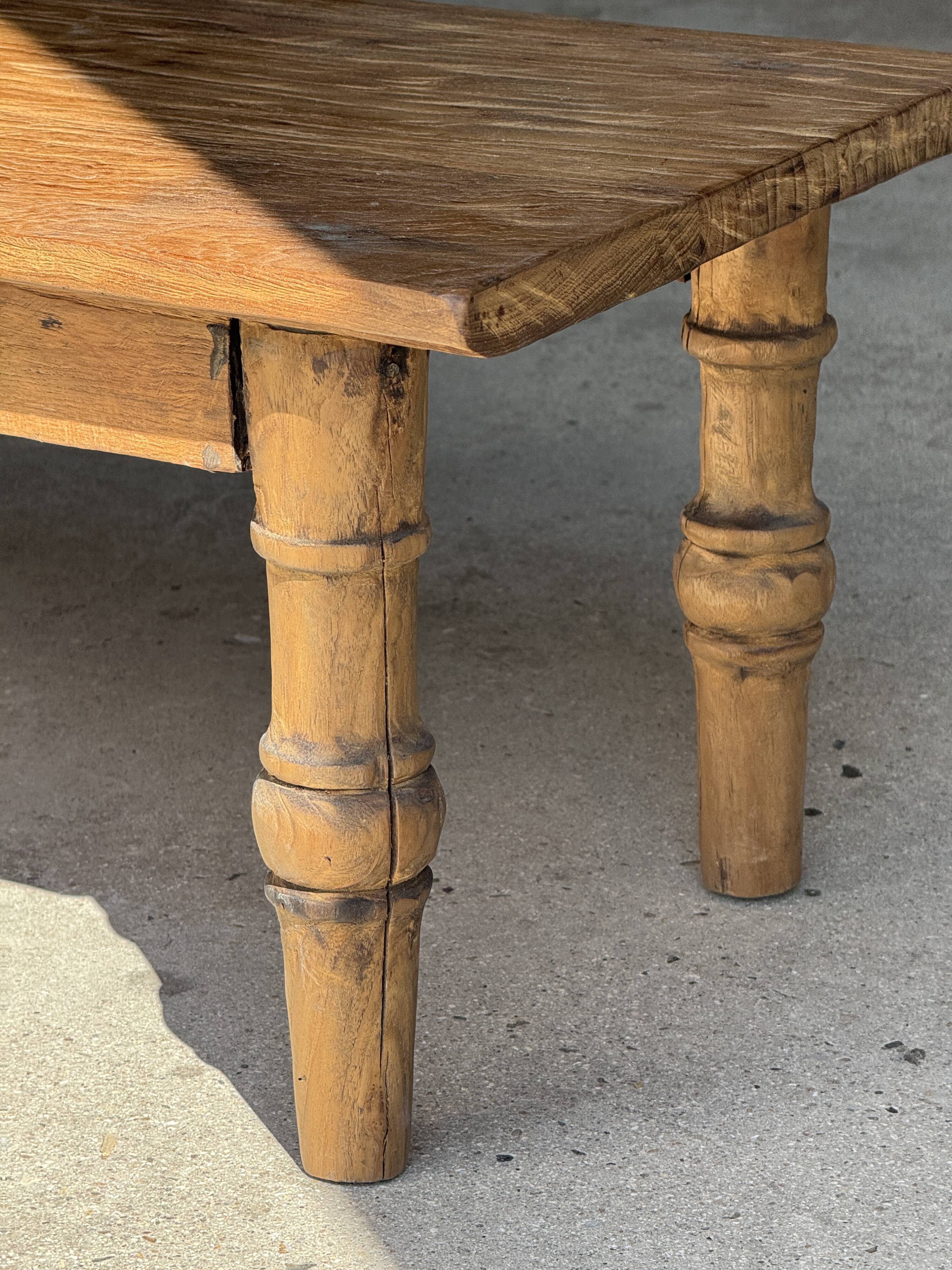 Brown Indonesian teak coffee table, with a border and cylindrical legs H40 L103.