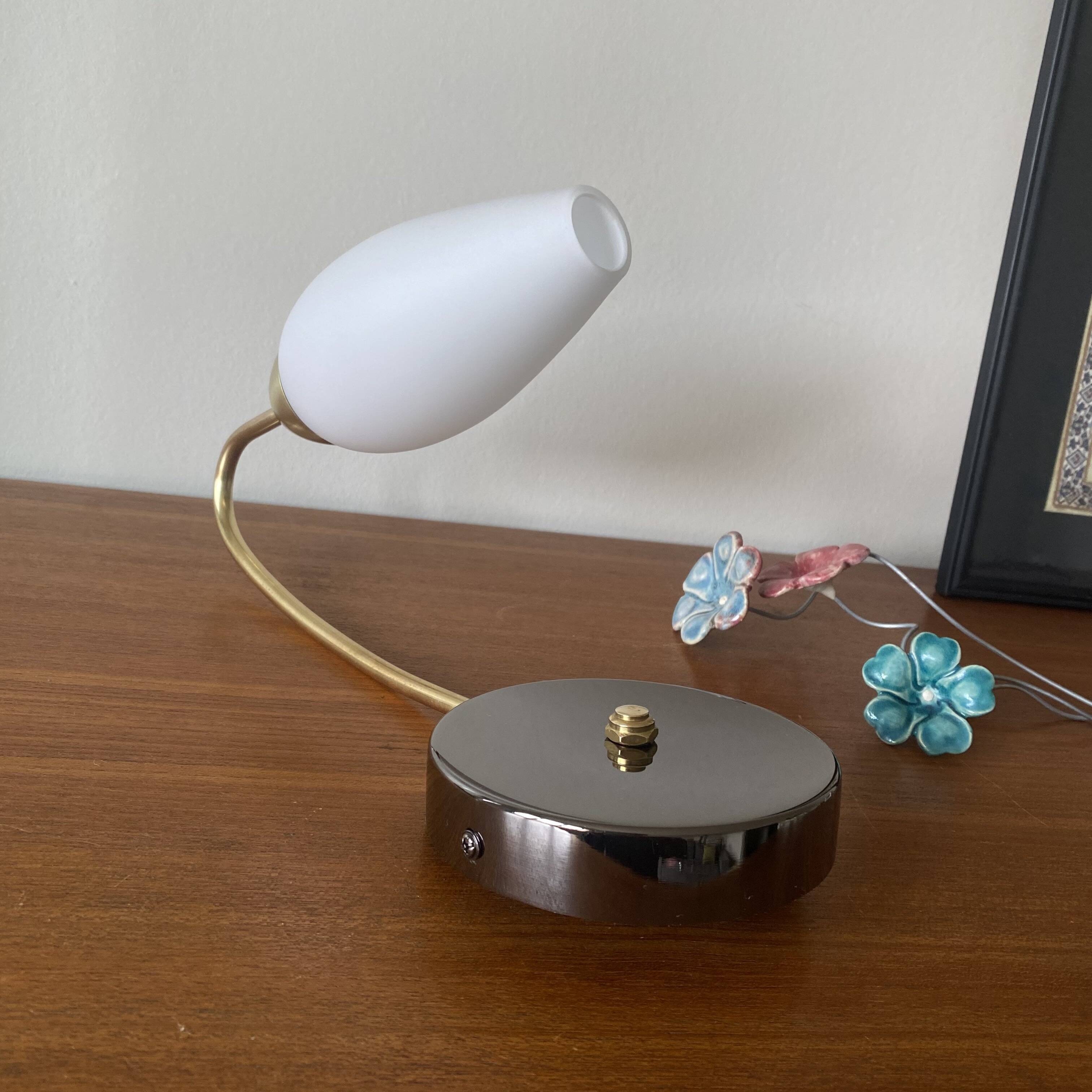 Swan neck wall light in brass and white opaline glass tulip.