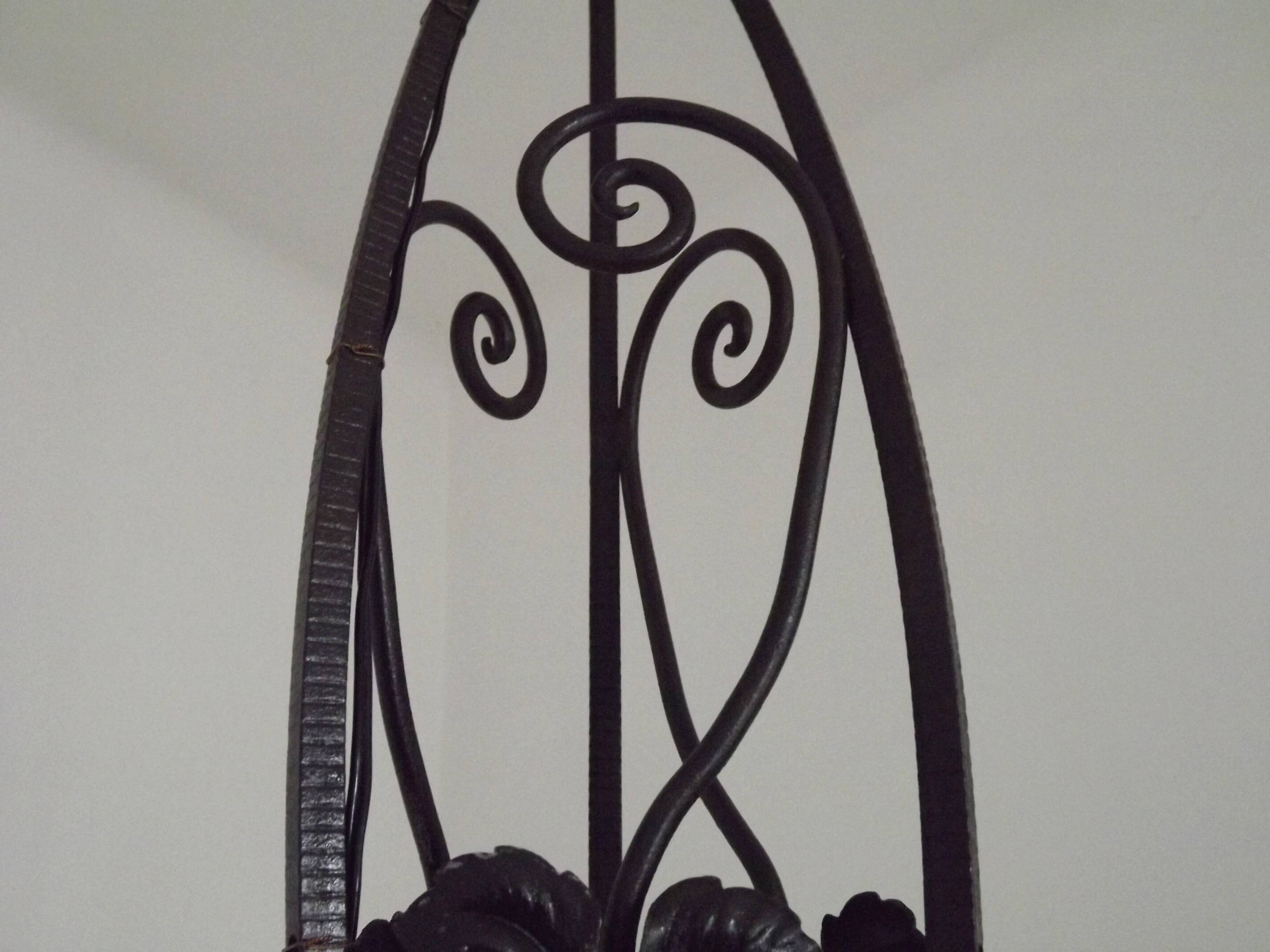 French Art Nouveau leaf detail iron three-light chandelier with amber glass shades.