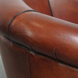 Sheepskin club armchair in a warm deep colour finished with black piping