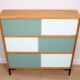 A vintage mid-century 3 tiered bookcase with glass sliding doors