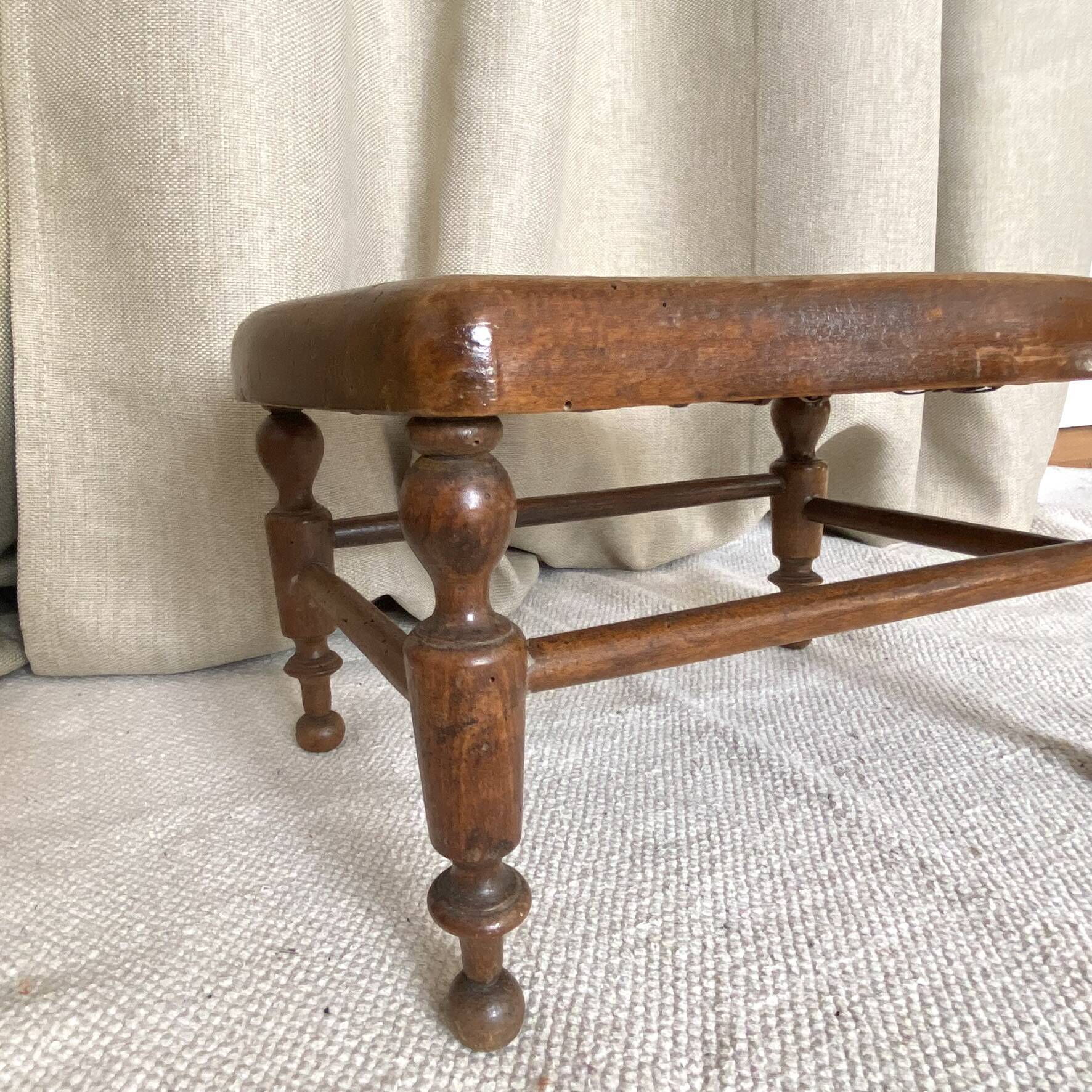 Low wooden stool with caning, footrest.
