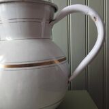 Old enamelled metal jug with gold trim.