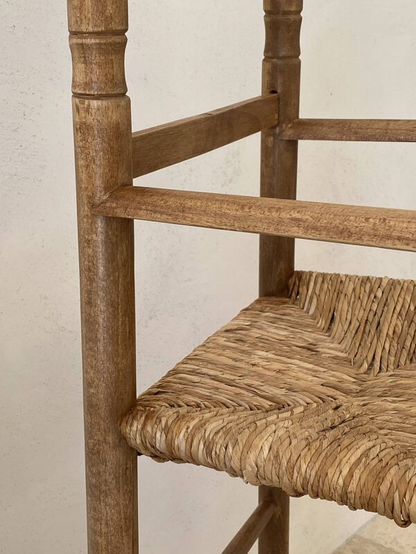 Ancienne chaise haute d’enfant en bois massif avec assise paillée.