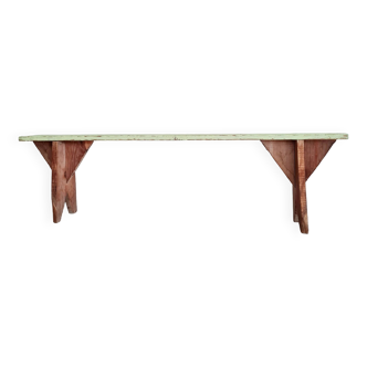 Old wooden farm bench with patinated green seat