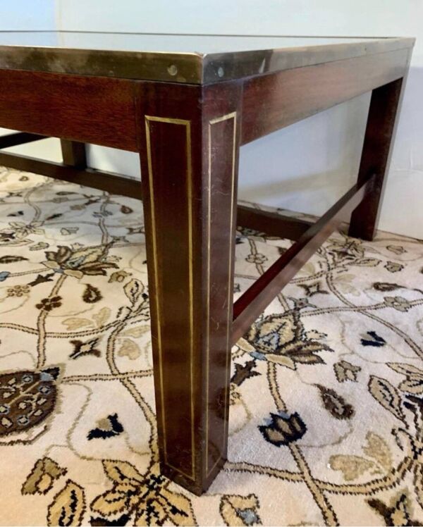 Table basse en bois exotique, garniture laiton et planisphère sous verre.