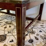 Table basse en bois exotique, garniture laiton et planisphère sous verre.