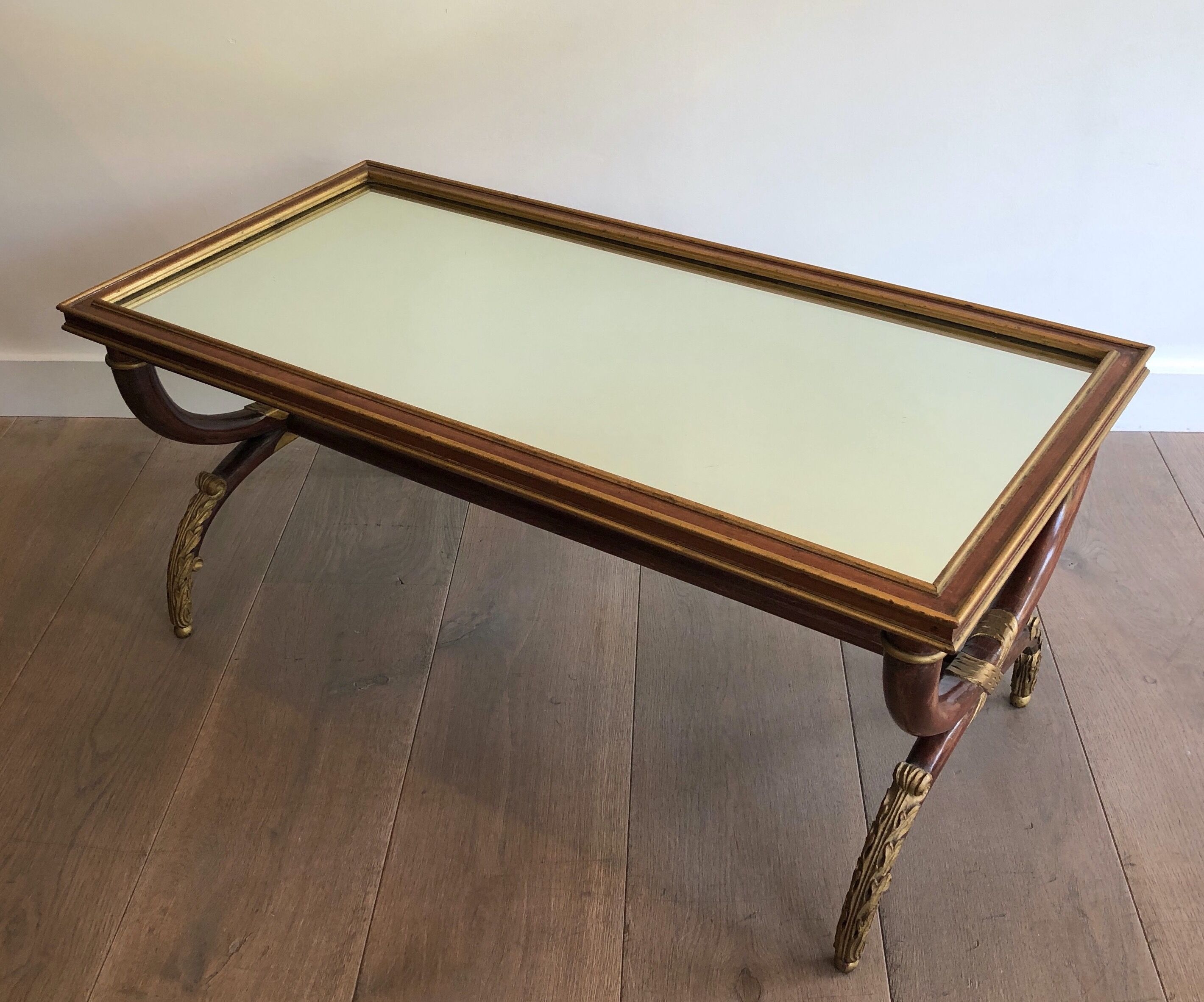 Coffee table in patinated and gilded carved wood with mirror top