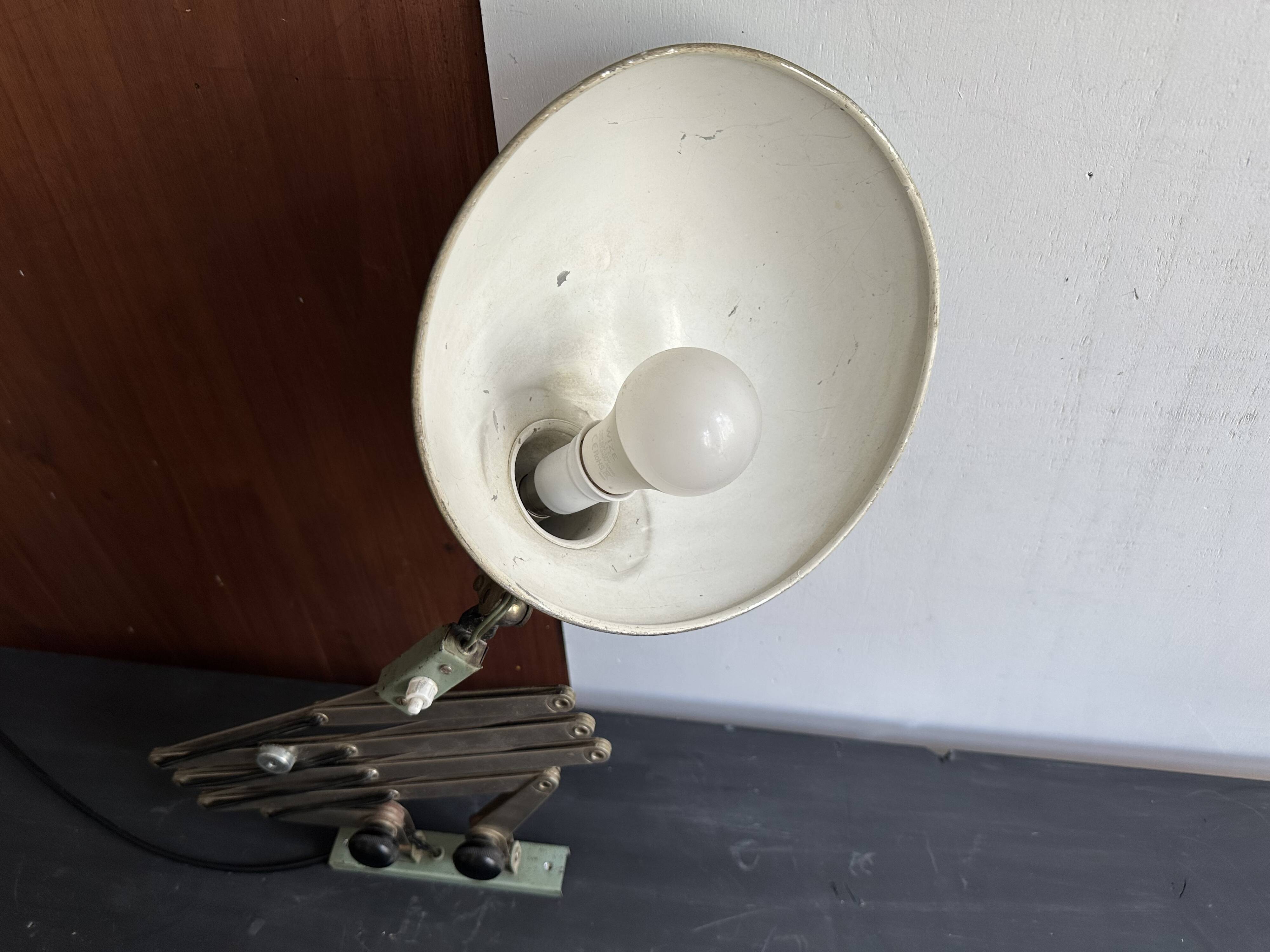 Old extendable accordion lamp in celadon green, workshop spirit.