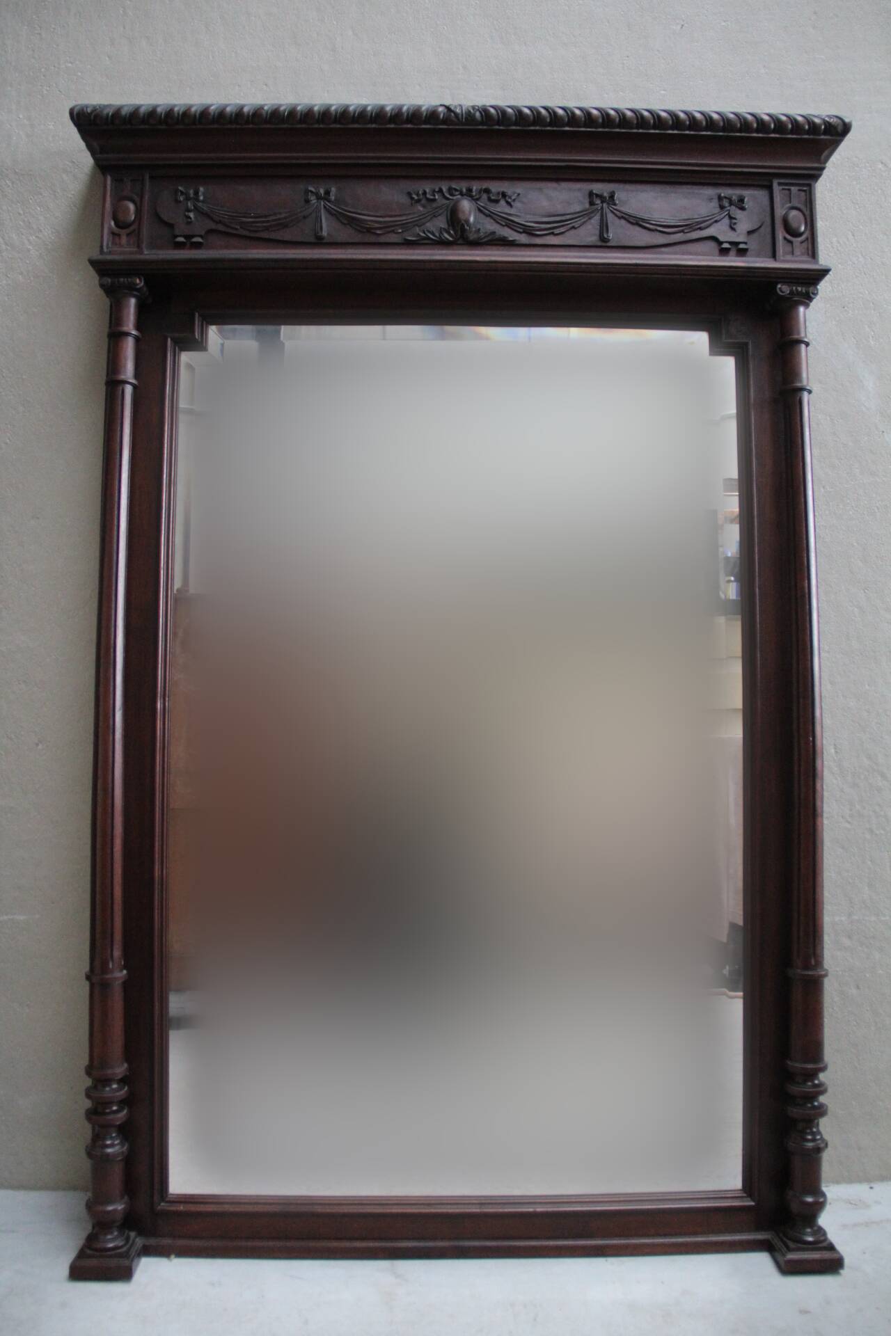 Imposing beveled mirror with wooden frame