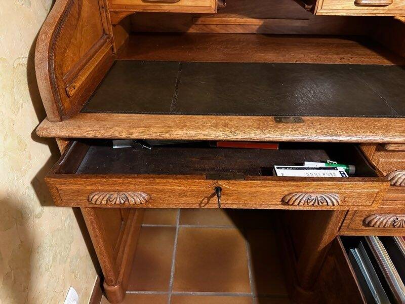 Oak desk with sliding door and leather wood chair.