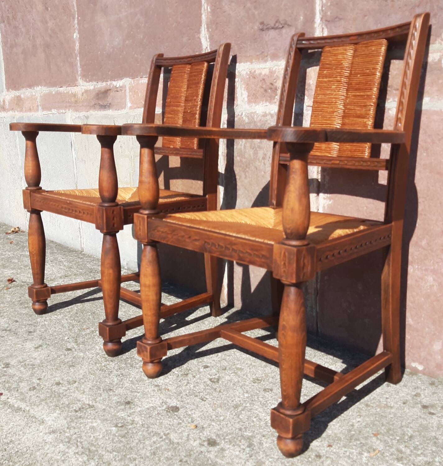 Pair of oak armchairs with straw seats and backs.