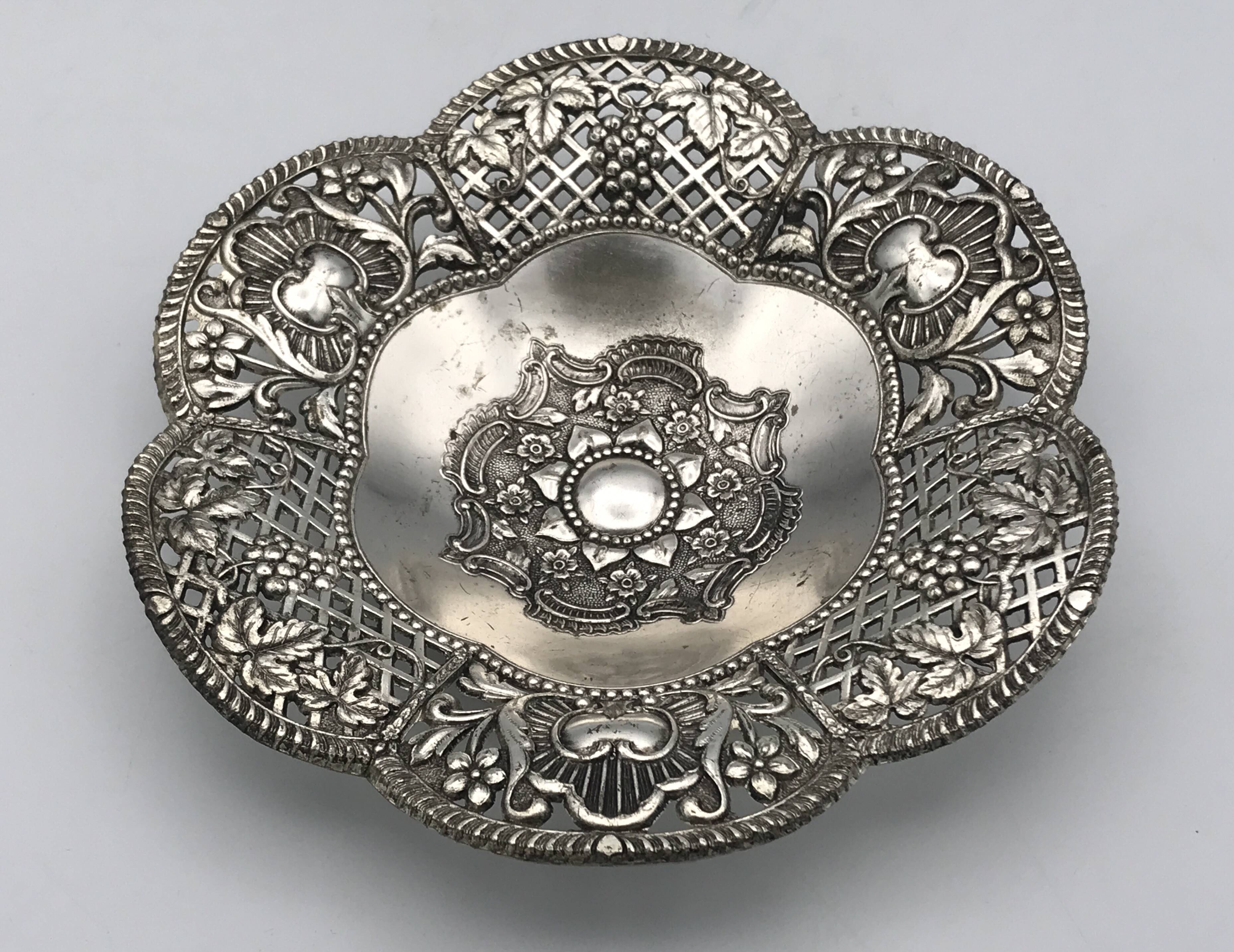 Silver-plated metal pocket emptier with openwork outline decoration