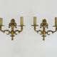 Pair of two-armed fire pot wall lights in gilded bronze.