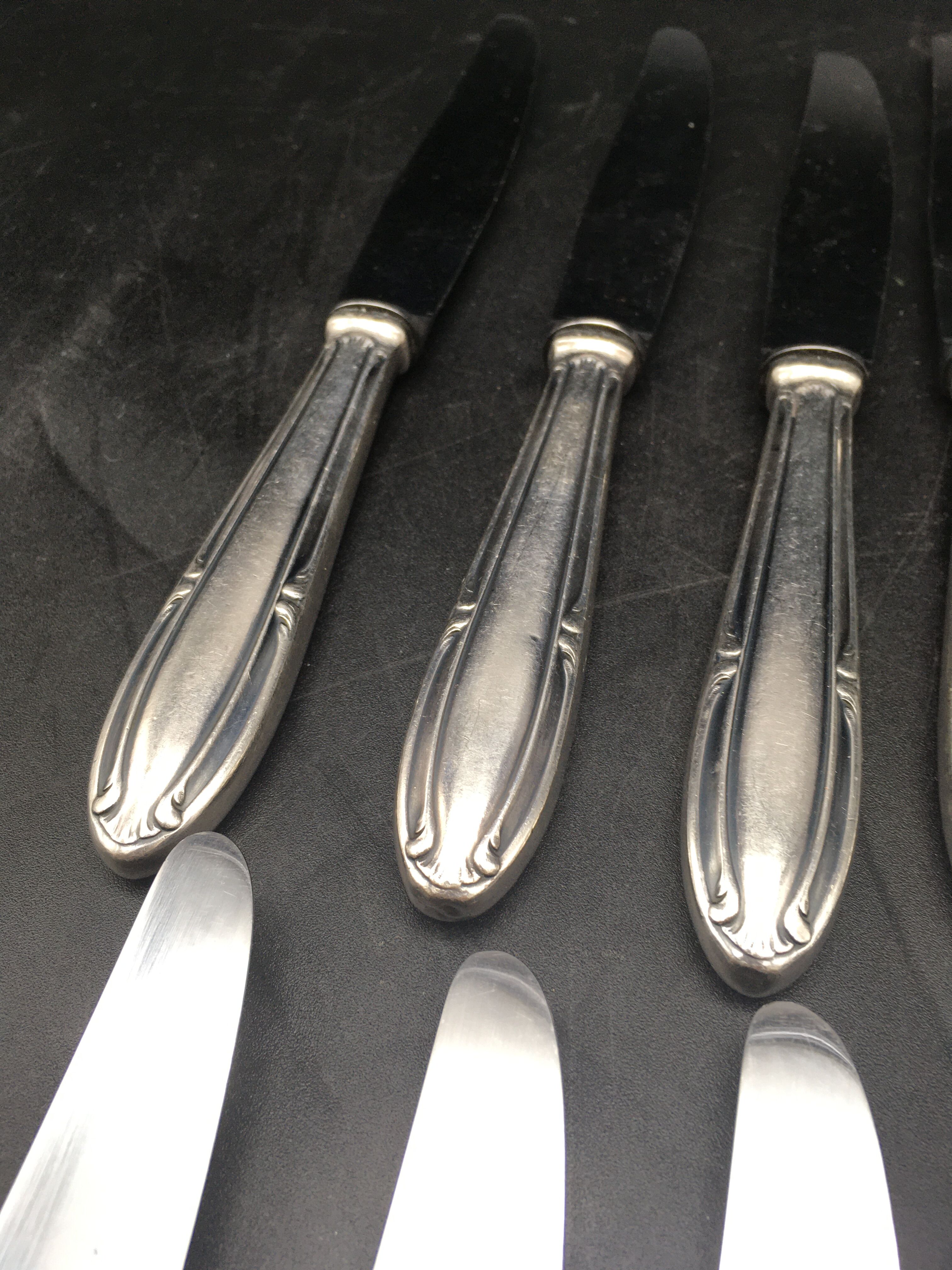 9 table knives in silver metal.