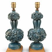 Une paire de lampes bleu clair iridescentes, avec un design de buisson floral.