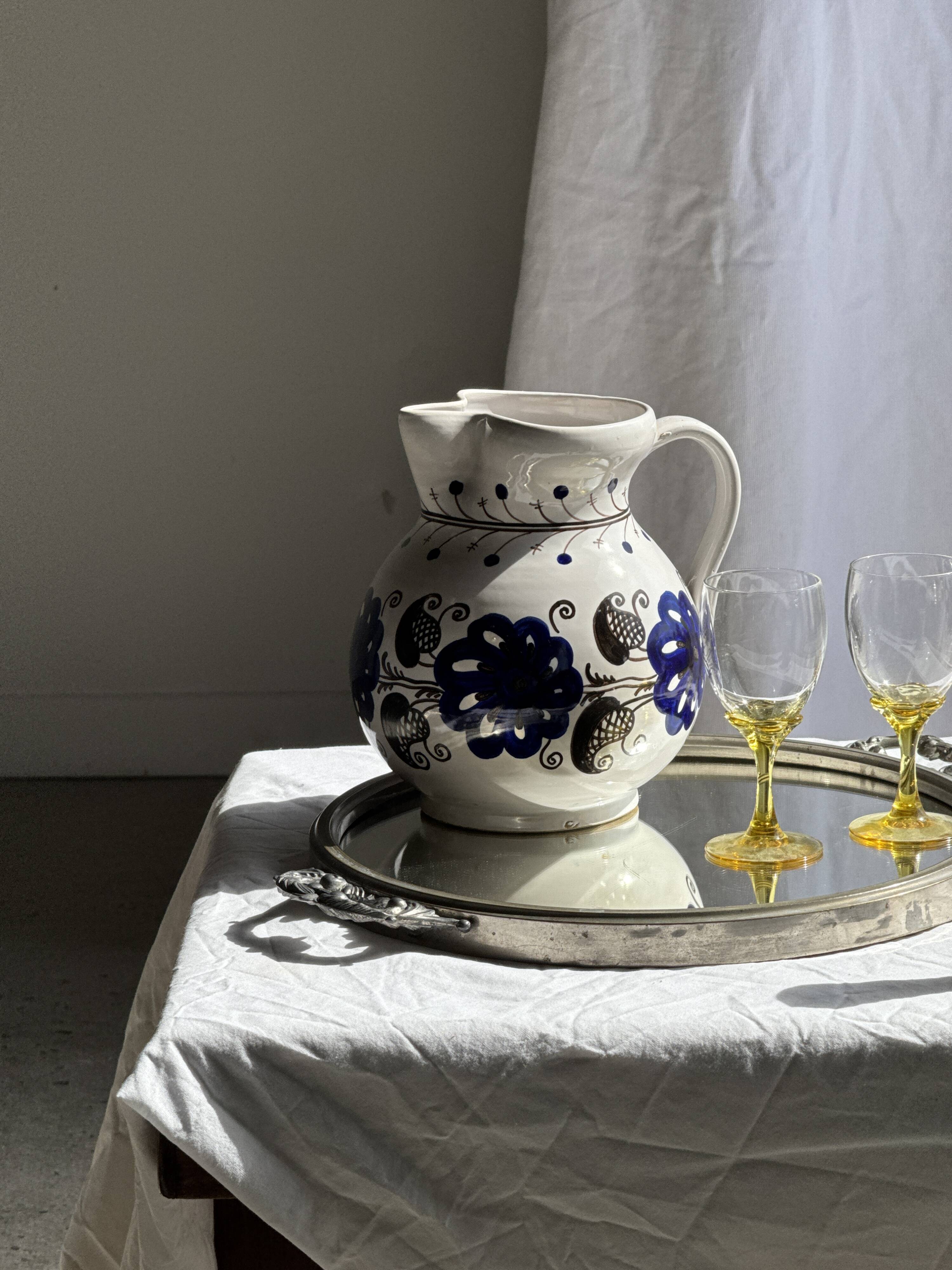 Very large vintage ceramic carafe in white glazed with blue floral decoration.