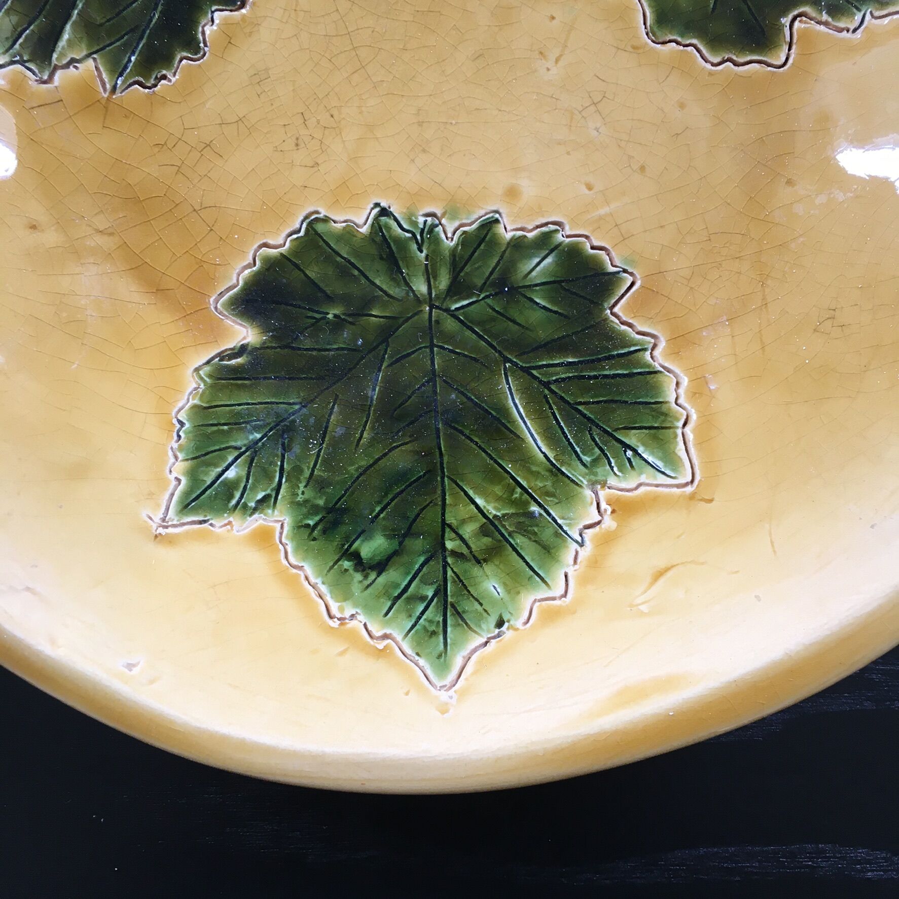 Plate signed with green leaf decoration.