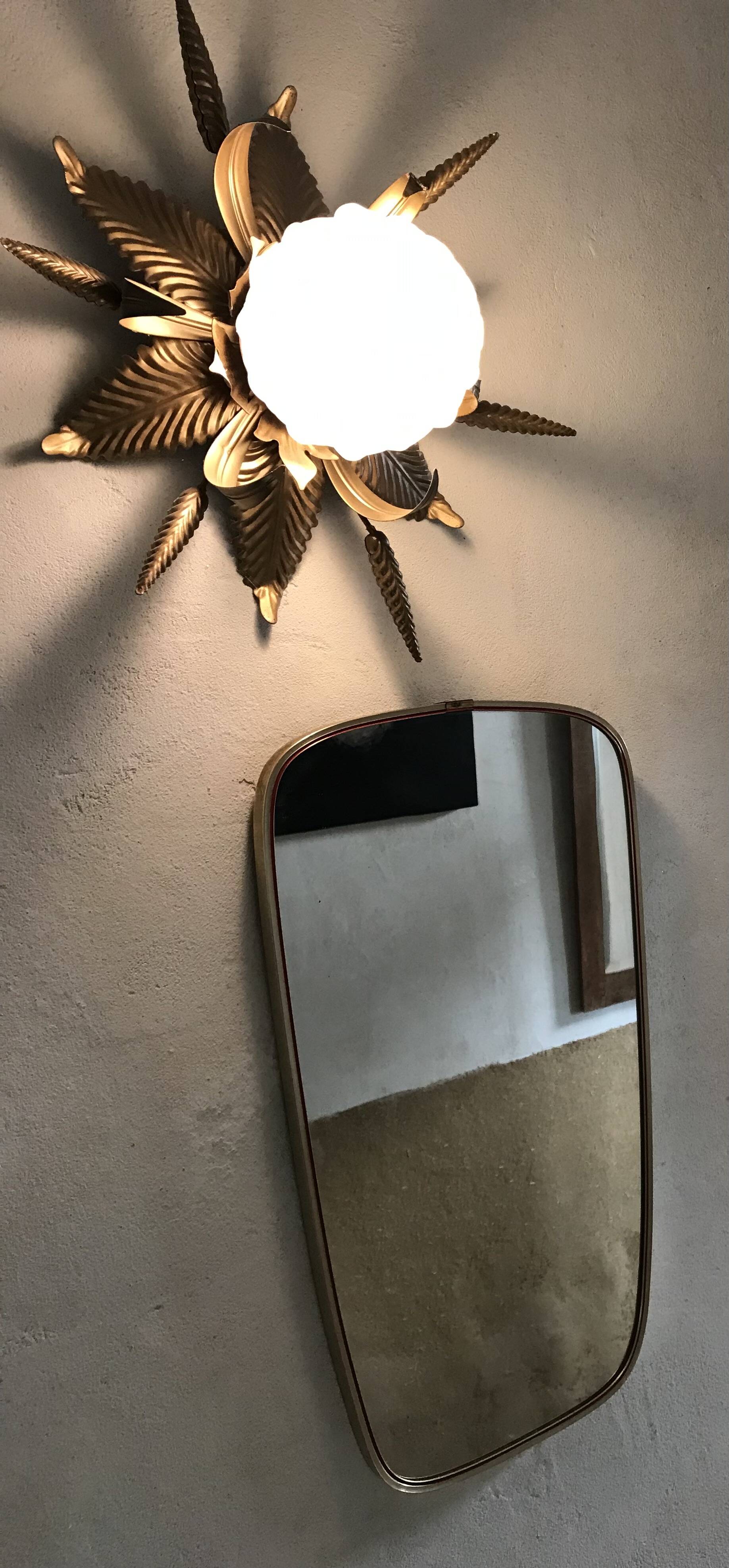 Vintage 1960s mirror in a freeform shape with a gold and red trim.