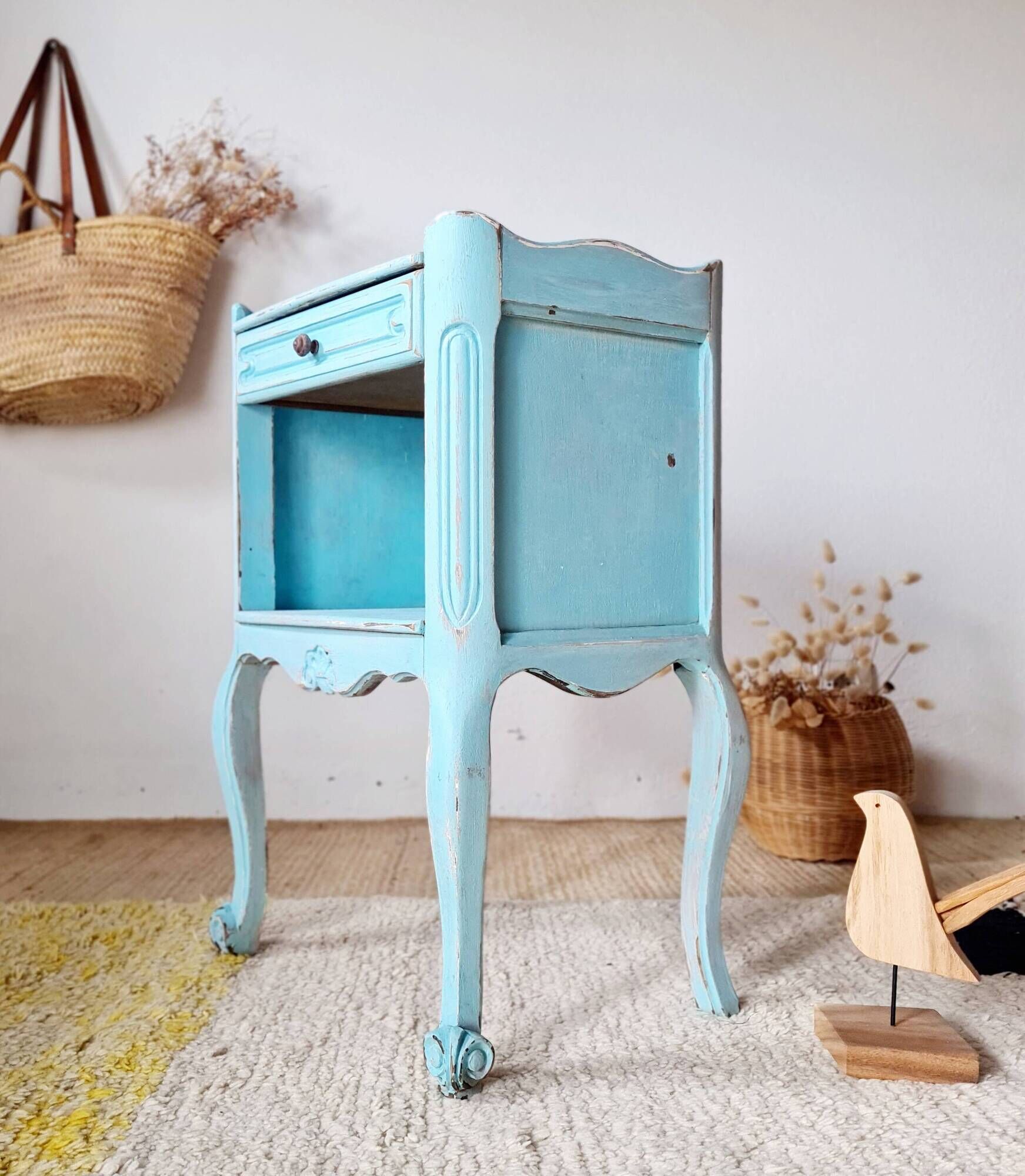 Small vintage bedside table with patinated azure blue wood.