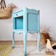 Small vintage bedside table with patinated azure blue wood.