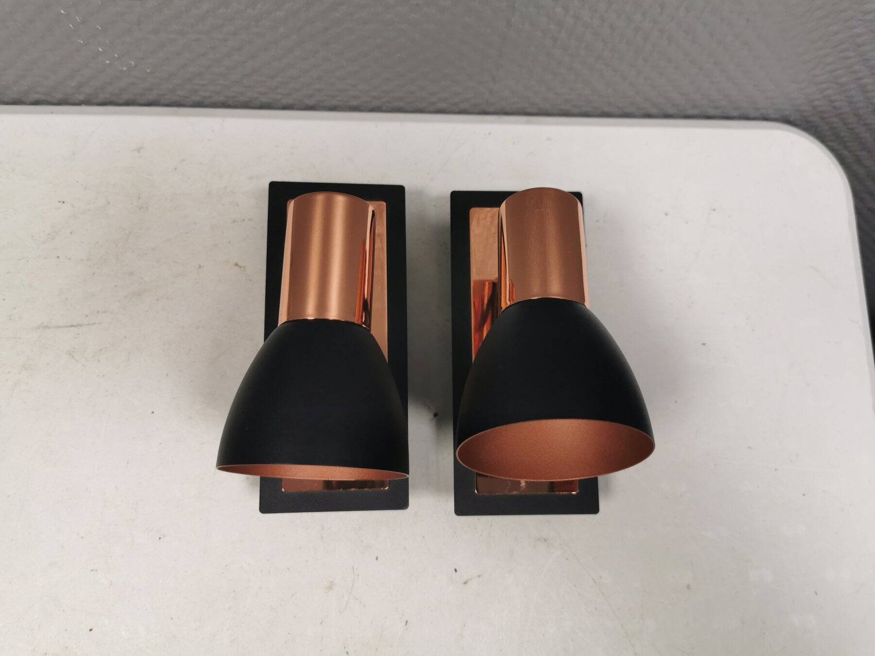 A pair of wall lamps from Eglo, in copper color and black.