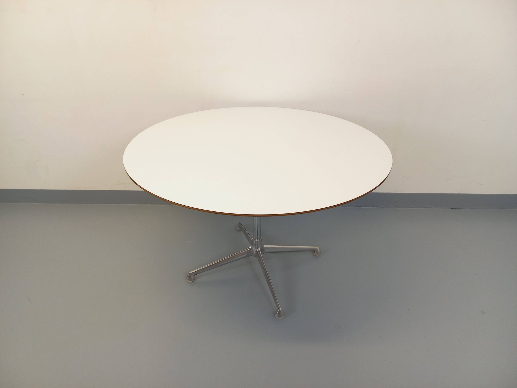 Vintage Eames round table for Vitra in white melamine, wood, and metal.
