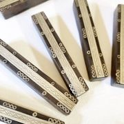 Set of 11 ebony wood knife rests with brass inlay