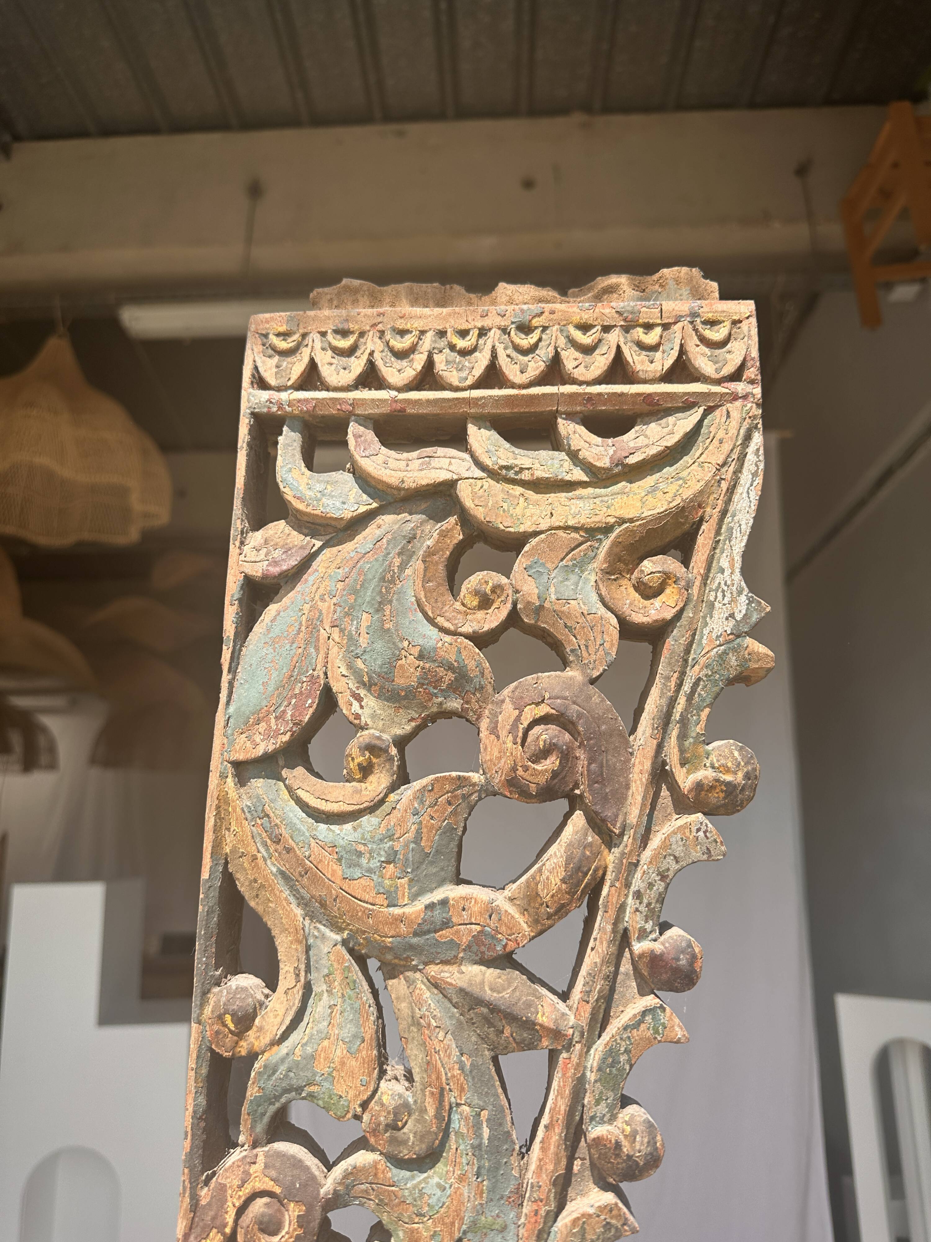 Indonesian construction element in carved wood with intertwined plant motifs mounted on a base (fri
