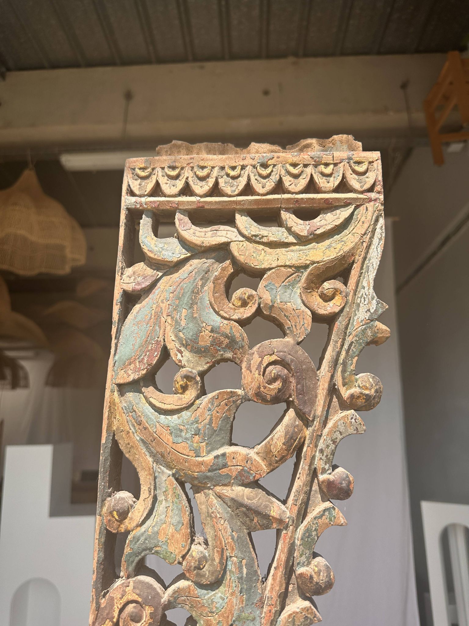 Indonesian construction element in carved wood with intertwined plant motifs mounted on a base (fri