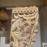 Indonesian construction element in carved wood with intertwined plant motifs mounted on a base (fri