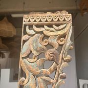 Indonesian construction element in carved wood with intertwined plant motifs mounted on a base (fri