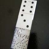 Complete set of miniature dominoes in black and white box.