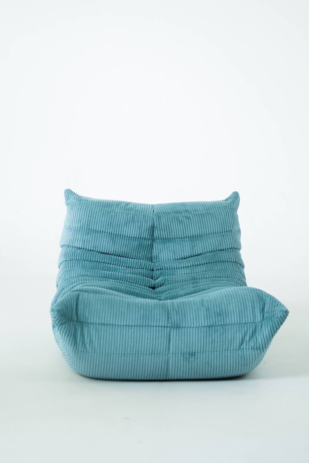 Ensemble de fauteuil et pouf Togo en velours côtelé bleu clair.