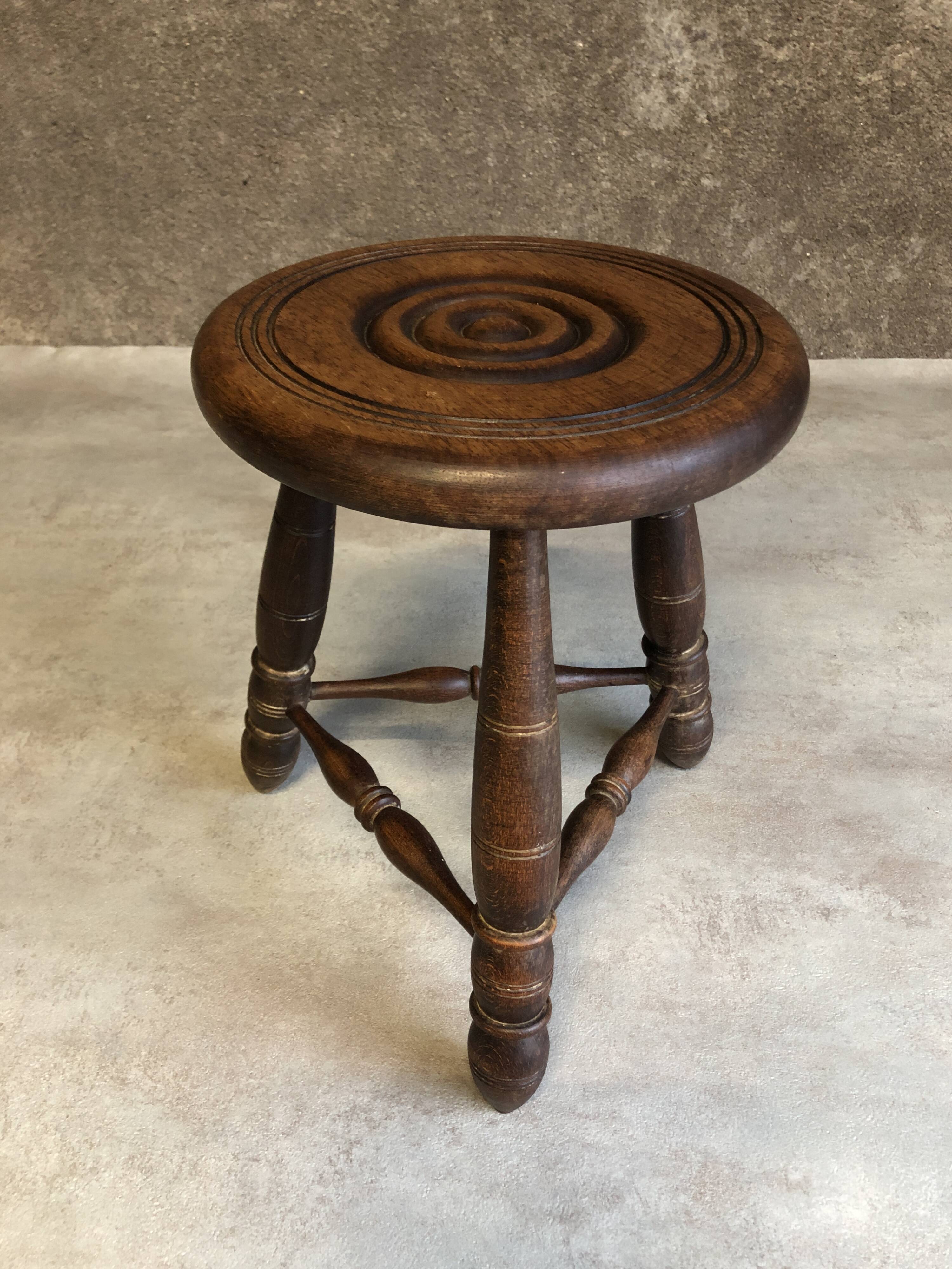 Round tripod stool in dark wood