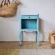 Small vintage bedside table with patinated azure blue wood.