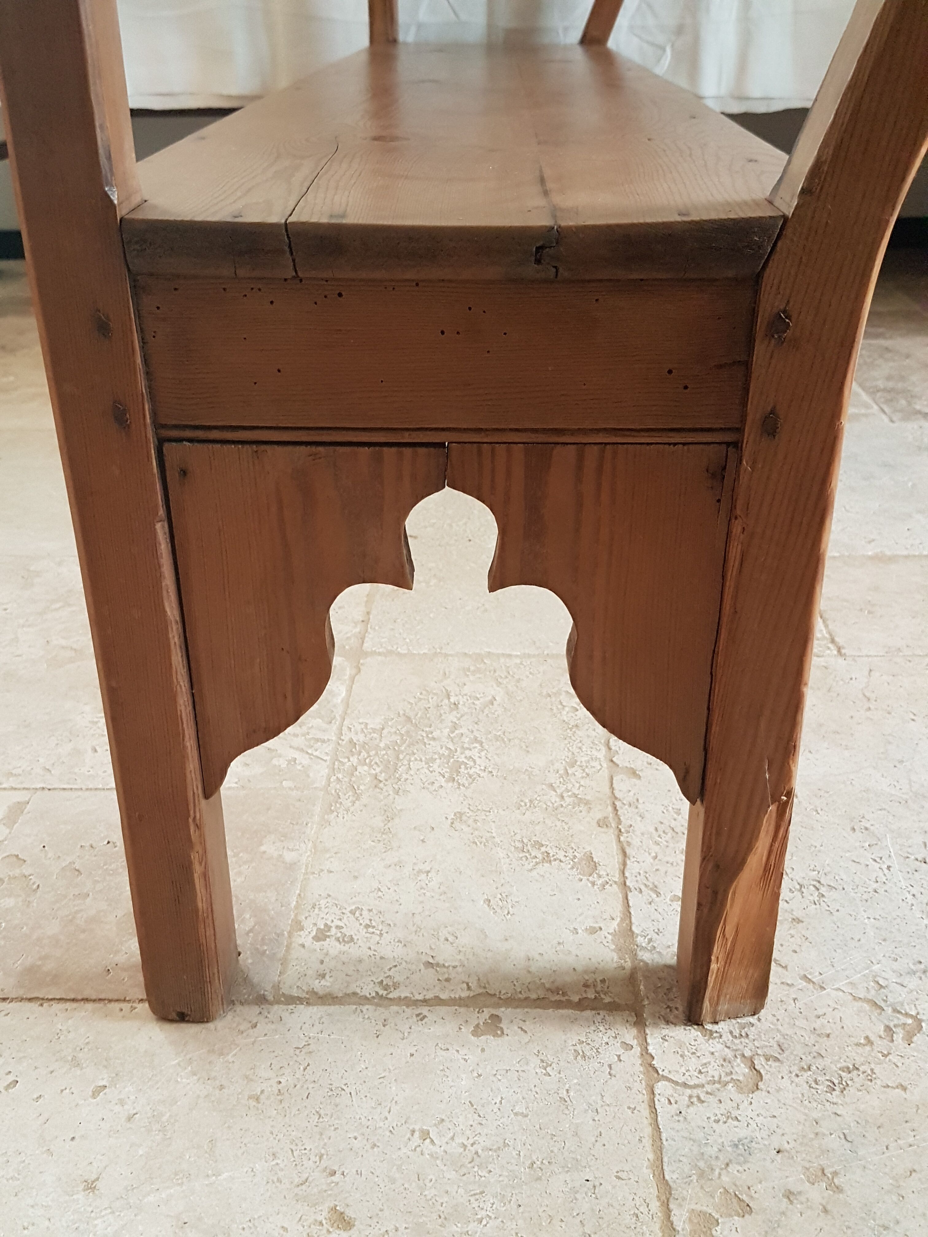 Church bench in fir tree with armrests