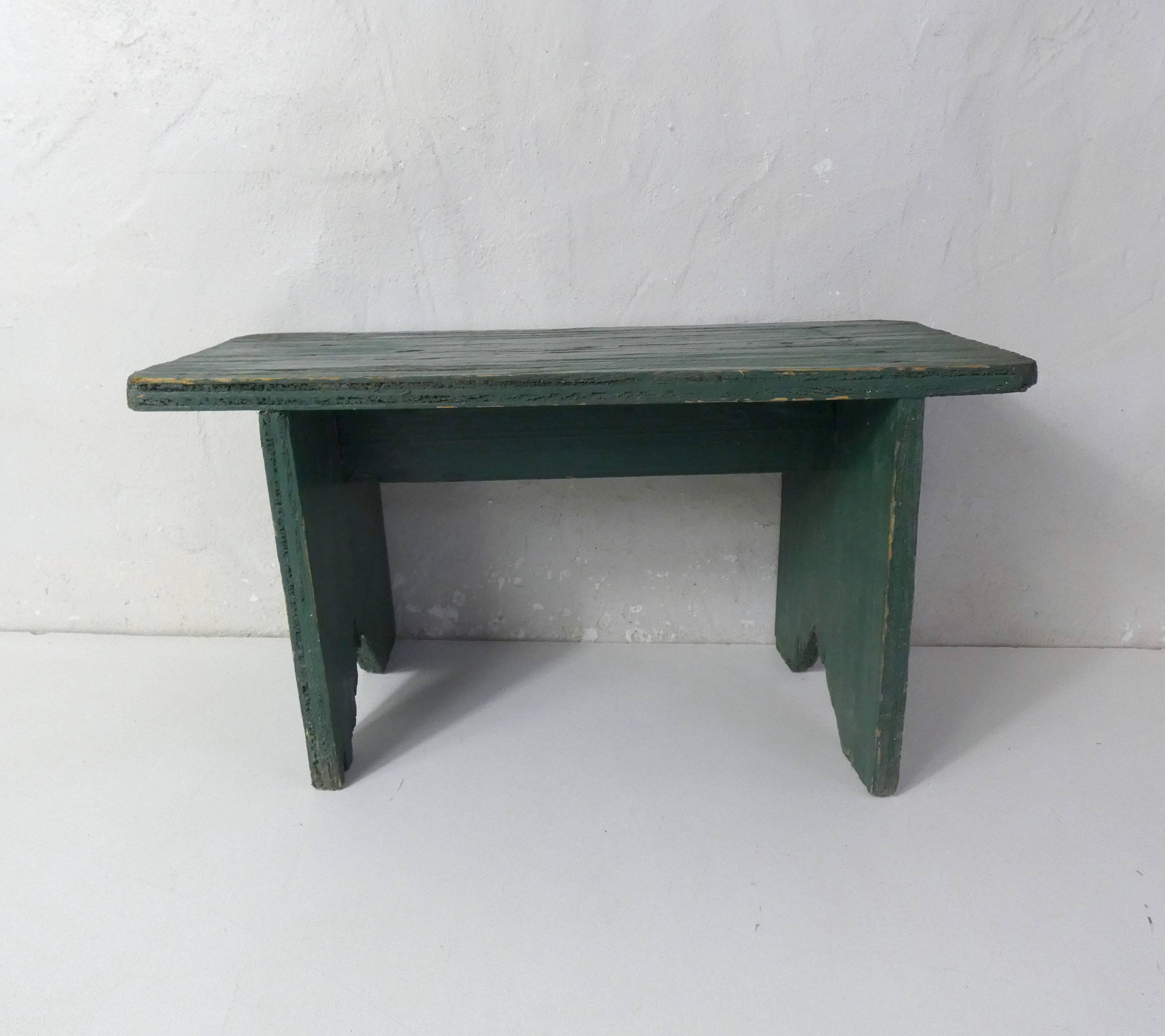 Old small wooden bench with green foot