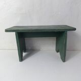 Old small wooden bench with green foot