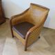 Colonial style armchair in woven rattan and exotic wood