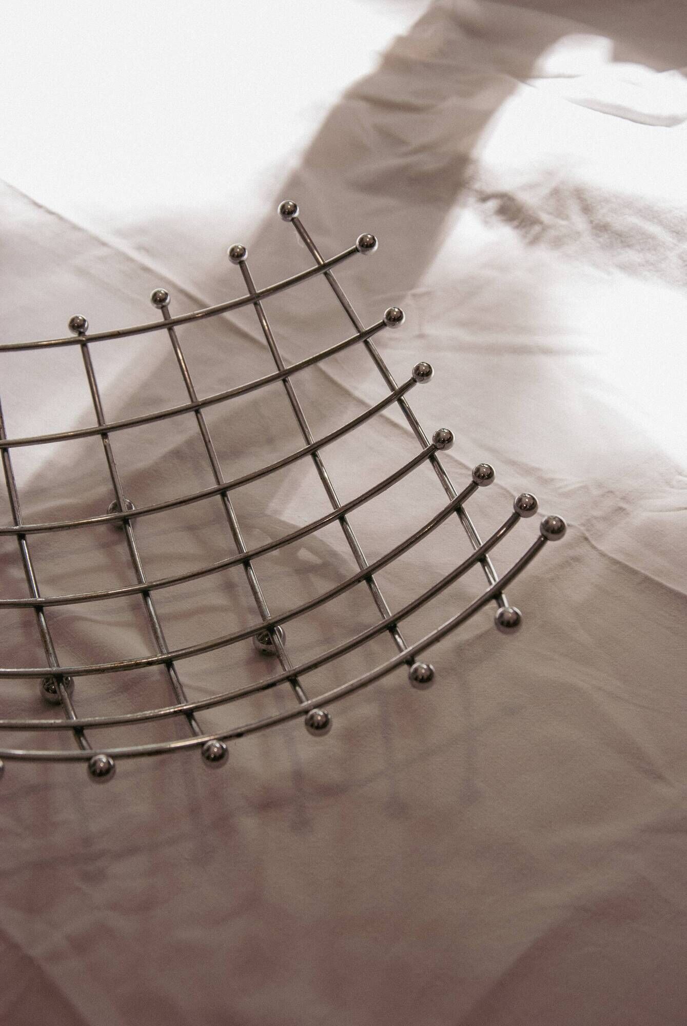 Curved grid fruit bowl, chrome metal and beads.
