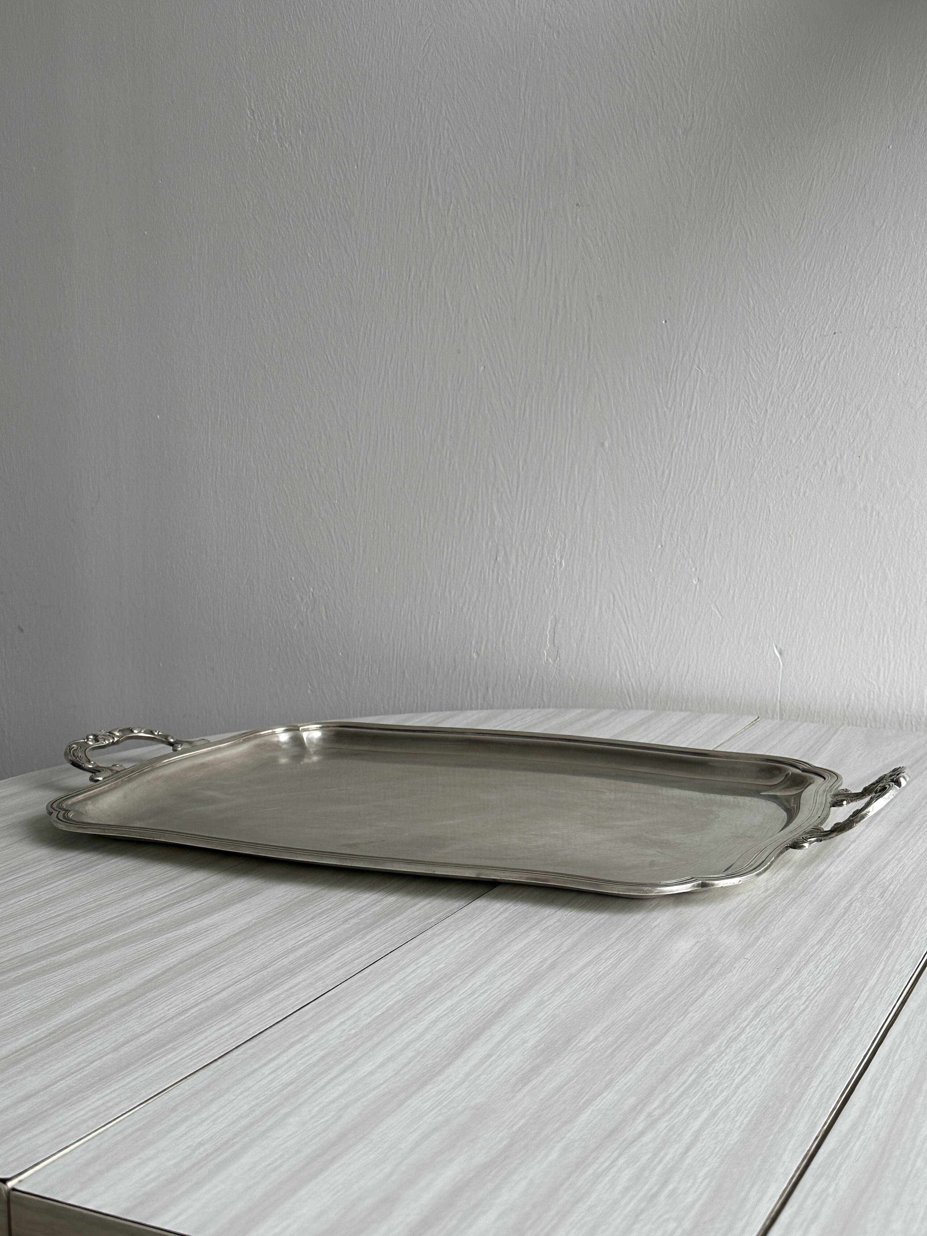 Silver metal serving tray with sculpted handles