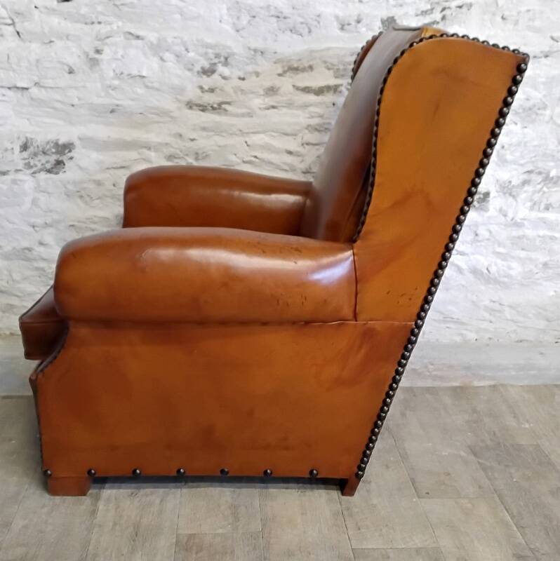 Living room with a sofa and wingback armchairs.