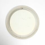 Mid Century Modern round wall mirror with a white expanded metal frame