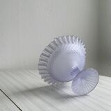 Purple glass pedestal bowl with wavy border and relief pattern.