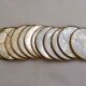 Set of 12 Mother of Pearl coasters with brass edging.