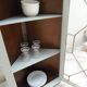 Vintage English corner display cabinet enhanced in grey-green with a wooden top.