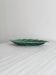Green earthenware dish in the shape of a leaf